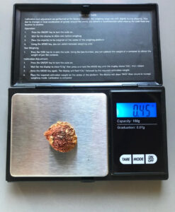 Le bouchon en forme d'amanite tue-mouches est pesé sur une balance de précision