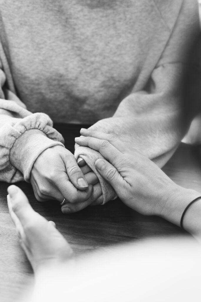 Hilfe bei emotionalem Schmerz – Ein liebevoller Begleiter für schwere Zeiten 4 Hilfe bei emotionalem Schmerz - jemand hält einer trauerden Frau die Hände