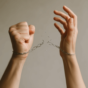 Toxische Beziehung lösen - gefesselte Hände sprengen Handschellen